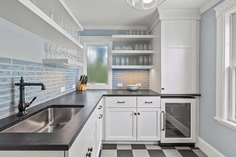 And a butlers pantry with a beverage refrigerator and wet bar