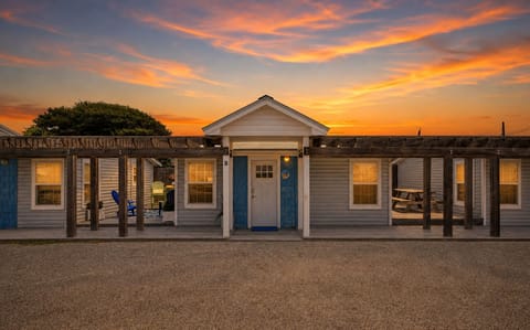 Twilight view of Flip Flop Inn with the blue Unit B entrance and covered outdoor areas.