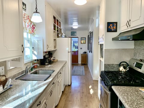 View in kitchen towards bedrooms to back room and patio door. 