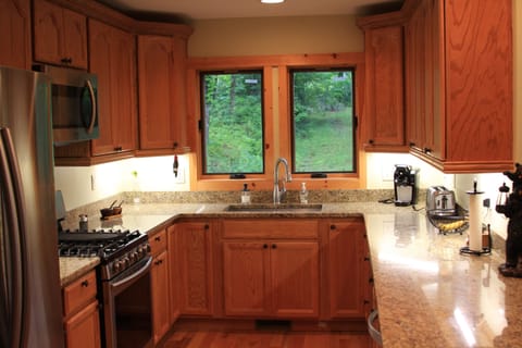Kitchen with granite counter tops and new stainless steel appliances.