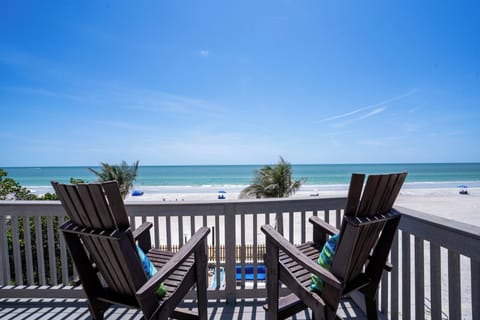 Large balcony set up with separate sitting areas with direct beach view