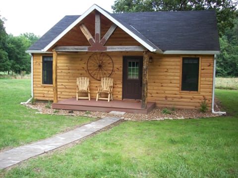 The exterior of the cabin in the summertime, with a view of the front porch.