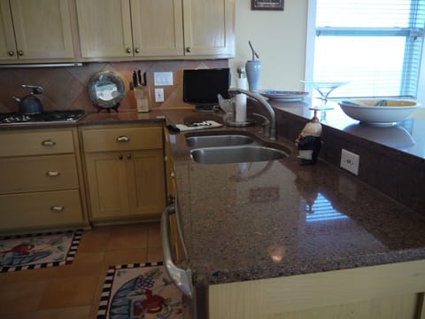 Granite countertops. Double sinks with another small sink on left of stove...