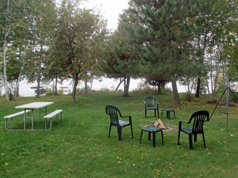 A picnic table, fire pit, tripod with grill, hot dogs, brats, s'mores.
