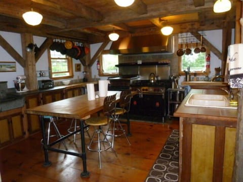 LOOKING INTO KITCHEN WITH DOUBLE SINKS AND LARGE COMMERCIAL STOVE