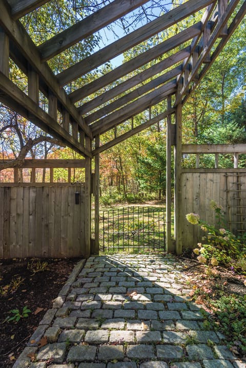 Covered garden walkway with pergola and stone path