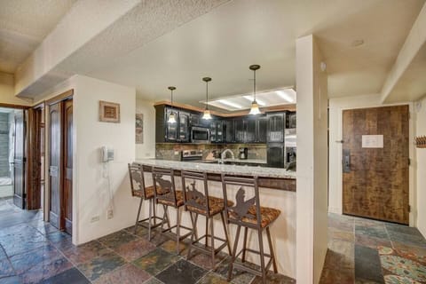 Kitchen features slab granite, stainless appliances and seating for 4 at bar.