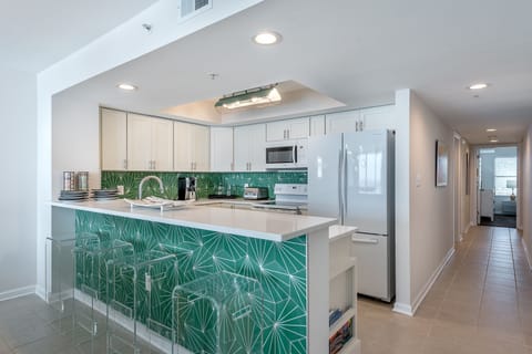 Bright kitchen with modern appliances, a spacious island, and seating for casual dining or entertaining