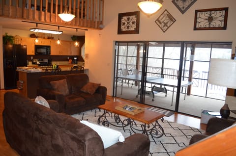 Living room overlooking sun room/game room and lake