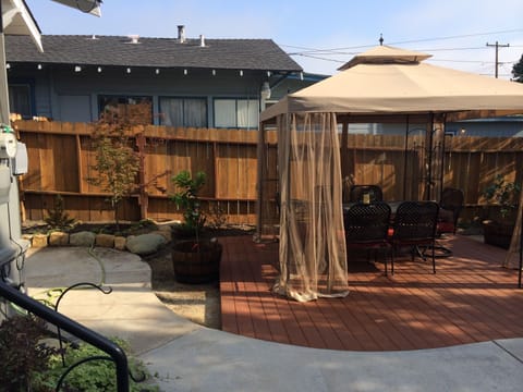 Backyard with dining area under canopy on raised trex decking