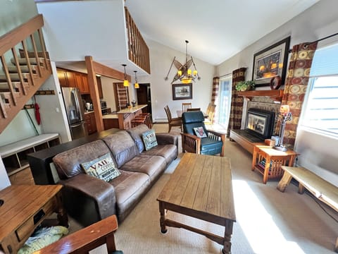 Living room with open floor plan and high ceilings, fireplace, and deck.