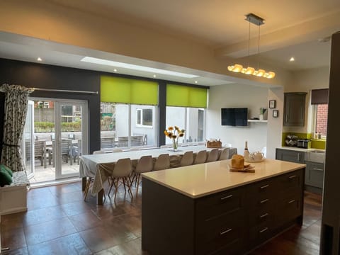 Dining table (for 18) & TV in kitchen with doors leading out to the patio