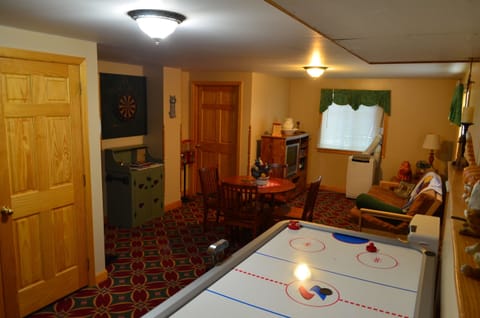 Downstairs game room features airhockey,, Dartboard, video arcade, TV and futon
