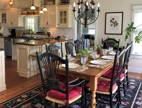 Table and chairs seat 8 in dining area, 4 more at round table in living room
