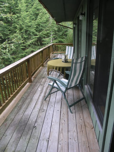 Deck overlooks woods and water