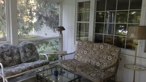 Screened in porch on the front of the house.  
2 sofa gliders, table and chairs.