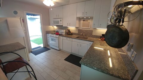 Spacious kitchen filled with all white plates, utensils, kitchen stuff.