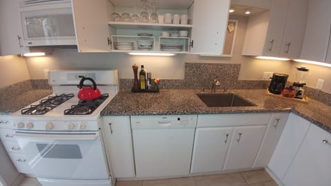 Spacious kitchen filled with all white plates, utensils, kitchen stuff.