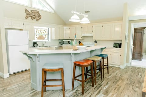 Open kitchen with lots of cabinet and counter space, and large breakfast bar