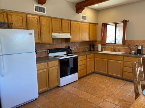 Fully stocked kitchen with refrigerator, oven, stove top, microwave
