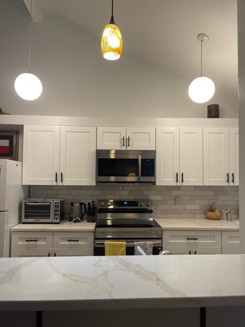 The kitchen after the remodel - new stove/oven and microwave, quartz countertops