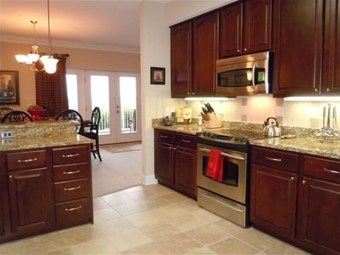 Upscale kitchen with stainless steel appliances, granite & Travertine