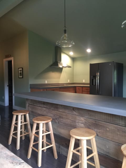 Concrete bar, stainless hood, side by side refrigerator, flat top stove