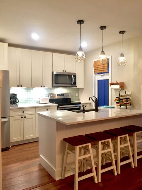 Stainless steel appliances, pendant lighting, shaker style cabinets, Pergo floor
