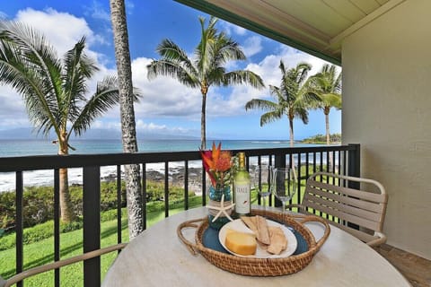 Unwind with snacks and a drink overlooking lush palms and sea.