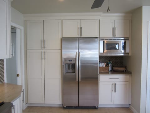 The kitchen has modern stainless steel appliances & solid surface counter tops