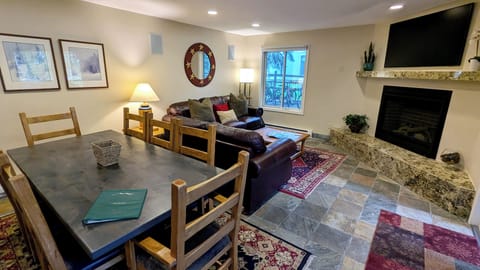 BC West Condo W-1 living room with dining table, sofa bed, and gas fireplace