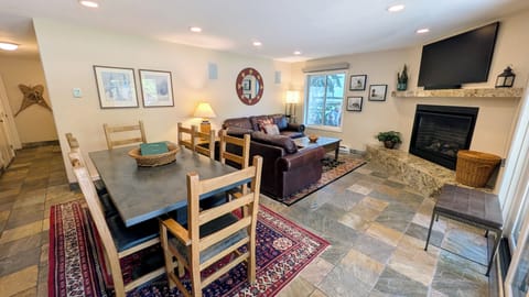 BC West Condo W-1 living room with dining table, sofa bed, and gas fireplace