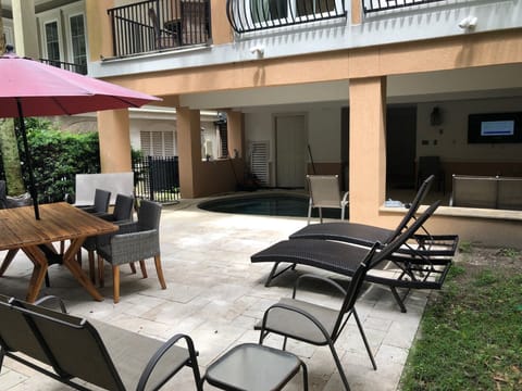 Patio with plenty of seating, sun lounge chairs, pool & TV