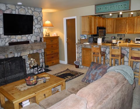Living room with HD television and view of kitchen.