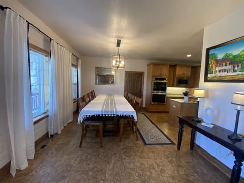 Entry with large dining table, open concept to kitchen and great room