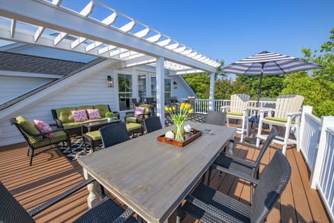 A spacious rooftop deck with ample seating for dining, lounging, and enjoying stunning ocean views.