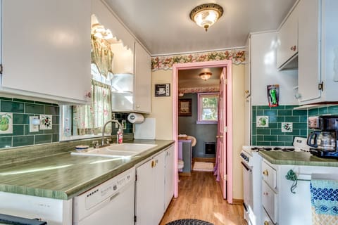 Cute galley kitchen with dishwasher is open to dining and living areas