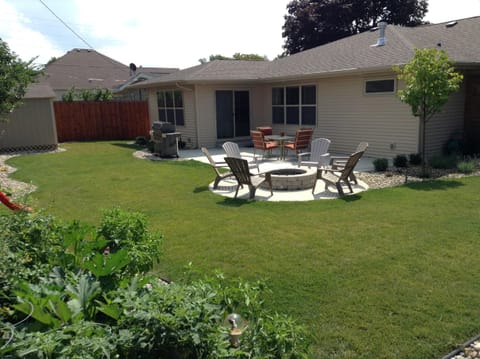 Backyard with in ground gas grill and gas fire pit. 