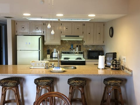  Barstools, kitchen counter refrigerator stove microwave coffeemaker spices etc. 