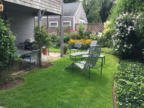 The back yard, with covered patio with dining for 8, grill and garden.