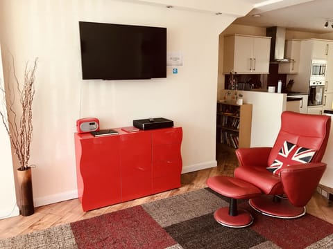 Red cabinet below TV holding DVDs, children’s toys & drawing & colouring