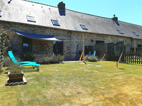 Jardin clos avec patio, pare-soleil, coin repas extérieur et barbecue.