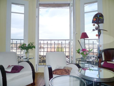 The living room offers a panoramic view over Paris and design armchairs