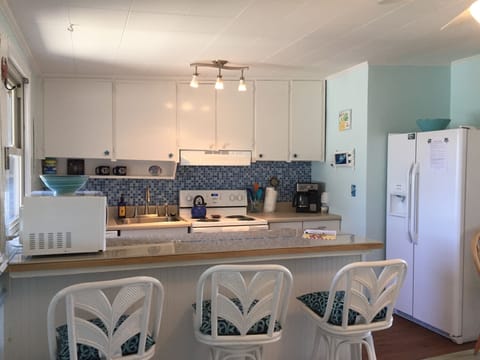 Kitchen has a breakfast bar - microwave, dishwasher, fridge & stove
