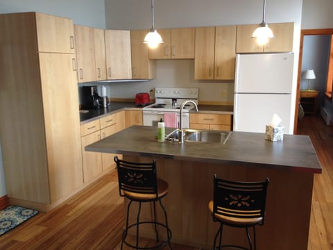 Full kitchen with a sit at island.