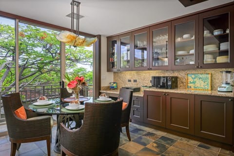 Casual dining space surrounded by windows and greenery—ideal for laid-back meals or coffee breaks.