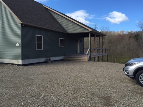 Main entrance and parking area. stairs leading to lower level next to main deck