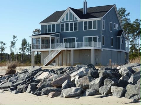 Enjoy wide water views, a deck with a screened-in porch
