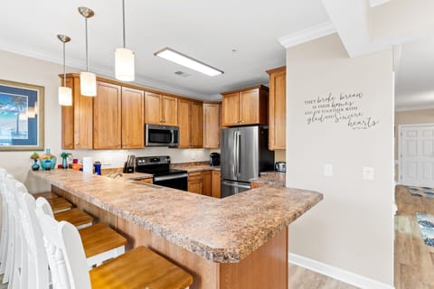 Kitchen and high bar view. 5 barstool seats in addition to dining table for 6.