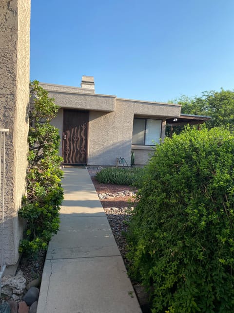 Front entrance to home with shaded porch and seating areas to the right